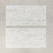 Close-up of Fitzrovia White natural marble tiles in a honed finish, 30.5x61cm format, showcasing a soft white base with gentle grey veining and subtle tonal variation, creating a timeless and refined look for wall and floor applications.
