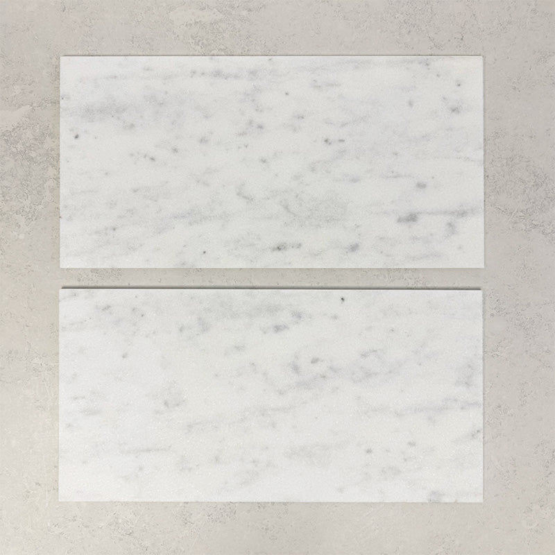 Close-up of Fitzrovia White natural marble tiles in a honed finish, 30.5x61cm format, showcasing a soft white base with gentle grey veining and subtle tonal variation, creating a timeless and refined look for wall and floor applications.