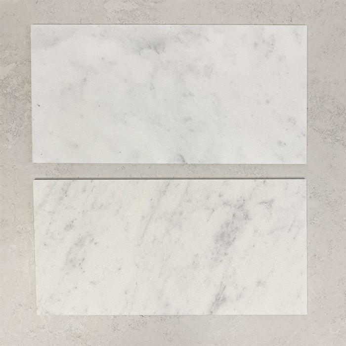 Close-up of Fitzrovia White natural marble tiles in a honed finish, 30.5x61cm format, showcasing a soft white base with gentle grey veining and subtle tonal variation, creating a timeless and refined look for wall and floor applications.