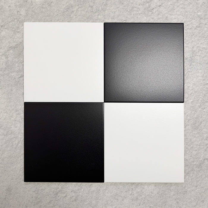 Four Chessboard White and Black 25×25cm Victorian-style porcelain tiles arranged in a classic chequerboard layout to showcase colour contrast, smooth satin finish, and pattern potential, displayed against a light textured background.