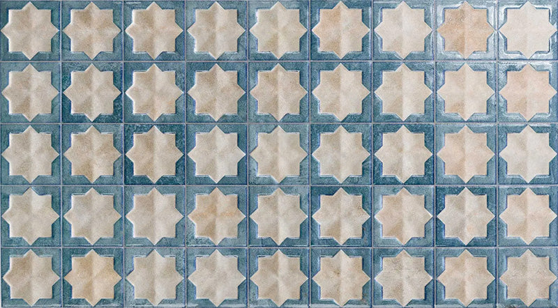 Close-up of Zeina Moroccan Arena Blue ceramic wall tiles featuring a Moroccan style geometric star pattern in soft cream and muted blue with a glossy finish, subtle shade variation and an aged handcrafted look for feature walls and splashbacks.