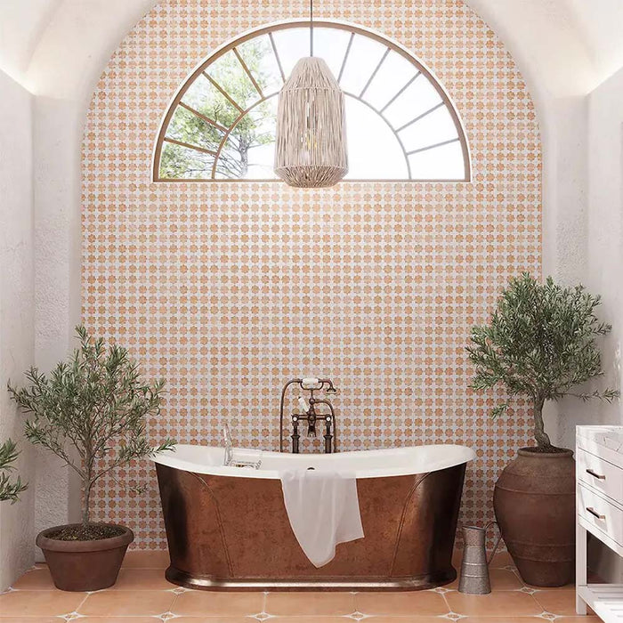 Bathroom featuring Zeina Moroccan Cotto White ceramic wall tiles in a repeating Moroccan style geometric pattern, paired with a freestanding copper bath, terracotta effect floor tiles, arched window, woven pendant light and olive trees for a warm Mediterranean-inspired retreat.