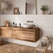 Bathroom featuring Zeina Moroccan Natural White ceramic wall tiles in a repeating Moroccan style geometric pattern, paired with a floating oak vanity, brushed brass wall-mounted taps, warm stone effect floor tiles, neutral décor and natural textures for a calm Mediterranean-inspired space.