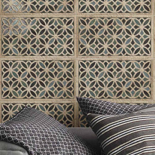 Close-up of Ziza Emerald Green Moroccan style decorative porcelain wall tiles, showcasing an intricate interlocking geometric pattern in rich emerald green, charcoal and warm stone tones with an aged finish, paired with textured charcoal cushions for a contemporary Moroccan-inspired living space.