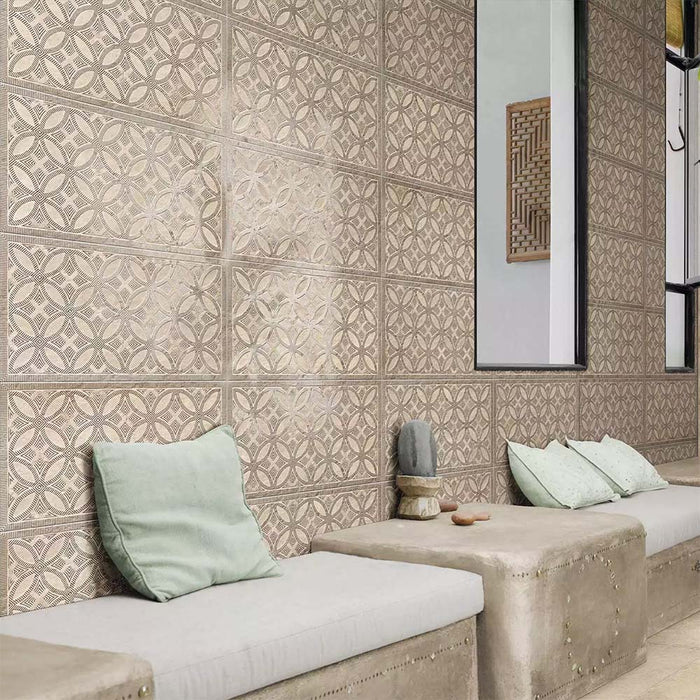 Bathroom featuring Ziza Sandy Beach Moroccan style decorative porcelain wall tiles, showcasing an intricate geometric floral pattern in soft sandy beige and taupe tones with textured engraved detailing, paired with built-in concrete seating, pale green cushions, black framed mirrors and natural finishes for a calm, contemporary Moroccan-inspired interior.