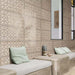 Bathroom featuring Ziza Sandy Beach Moroccan style decorative porcelain wall tiles, showcasing an intricate geometric floral pattern in soft sandy beige and taupe tones with textured engraved detailing, paired with built-in concrete seating, pale green cushions, black framed mirrors and natural finishes for a calm, contemporary Moroccan-inspired interior.