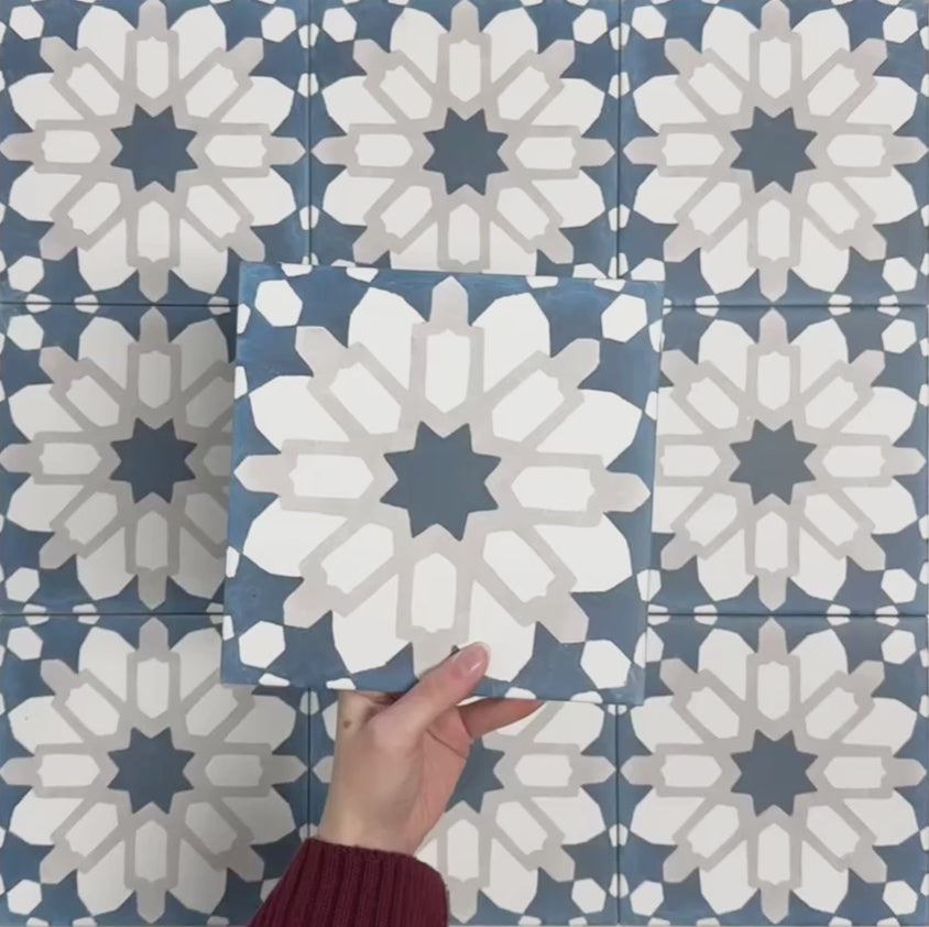Video showcasing Soukaina Blue D Moroccan-style 20cm x 20cm patterned porcelain tiles, highlighting the bold central star design, rich blue and neutral colour palette, and matt finish when laid together.