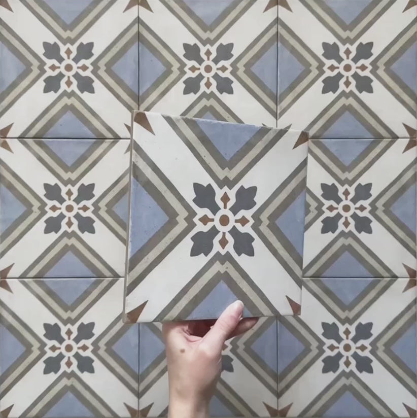 Video showcasing the Carnaby Turner Victorian-style 20x20cm porcelain wall and floor tiles, featuring close-up views of the blue, cream, and charcoal geometric cross pattern with small gold accents as the camera moves across the tiled surface.