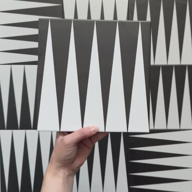 Rotating showcase of Alhambra Tavla 20x20cm Moroccan tiles featuring a striking black and white triangular pattern, highlighting the bold geometric design and matt finish.