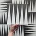 Rotating showcase of Alhambra Tavla 20x20cm Moroccan tiles featuring a striking black and white triangular pattern, highlighting the bold geometric design and matt finish.