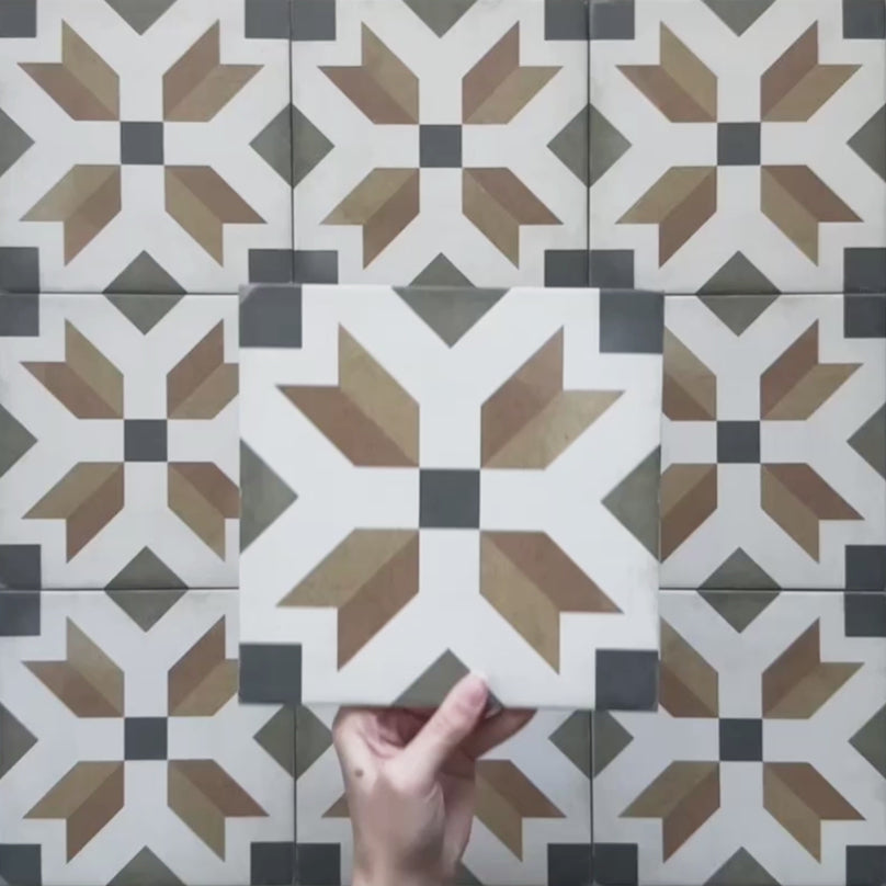 Video showcasing the Carnaby High Street Victorian-style 20x20cm porcelain wall and floor tiles, featuring close-up views of the bold geometric star pattern in mustard, olive, brown, white, and charcoal tones as the camera moves across the tiled surface.