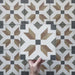 Video showcasing the Carnaby High Street Victorian-style 20x20cm porcelain wall and floor tiles, featuring close-up views of the bold geometric star pattern in mustard, olive, brown, white, and charcoal tones as the camera moves across the tiled surface.