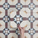 Video showcasing Europa Berlin 20x20cm Victorian Moroccan style tiles arranged together to showcase the repeating geometric star pattern in burgundy, blue, mustard and cream tones.
