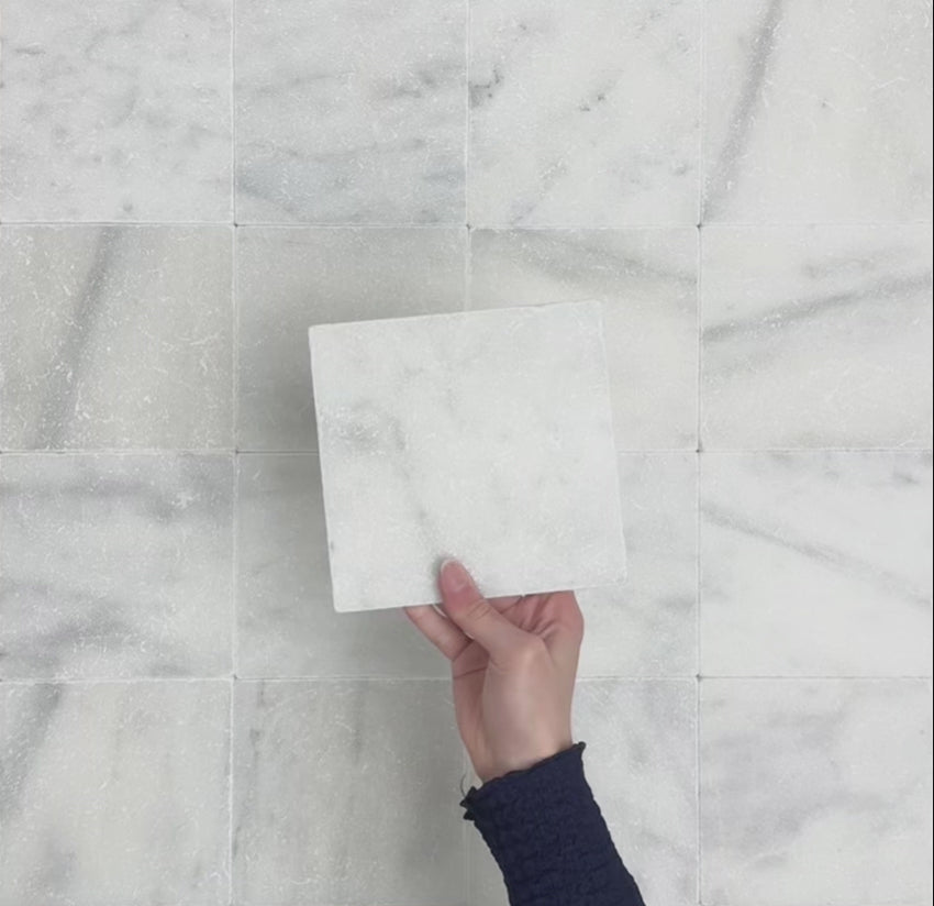 Video showcasing Fitzrovia White 15.2x15.2cm tumbled natural marble tiles arranged in a square layout, showcasing soft white tones, subtle grey veining, tonal variation, and an aged, lightly textured finish.