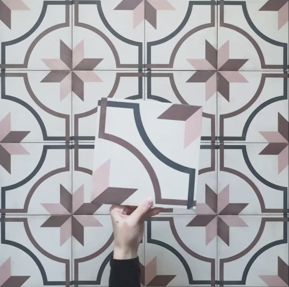 Video showcasing the Carnaby Rose Victorian-style 20x20cm porcelain wall and floor tiles, highlighting the pink and brown star motif with navy geometric detailing and the aged white background, displayed as the camera pans across the patterned surface.