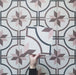 Video showcasing the Carnaby Rose Victorian-style 20x20cm porcelain wall and floor tiles, highlighting the pink and brown star motif with navy geometric detailing and the aged white background, displayed as the camera pans across the patterned surface.