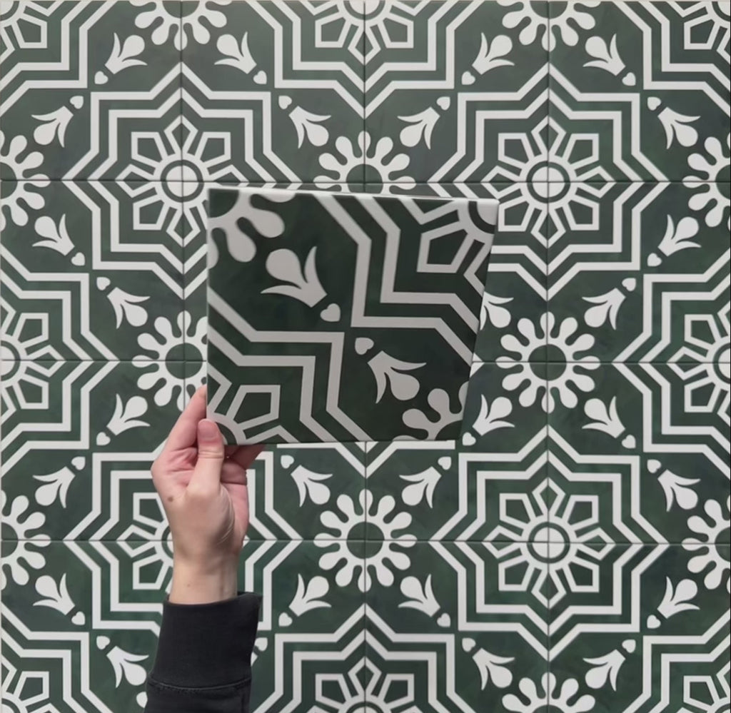 Video showcasing Brompton Victorian Green 20x20cm geometric patterned ceramic tiles with an intricate white floral and star motif on a deep green background, highlighting the detailed design and matte finish in a close-up view.