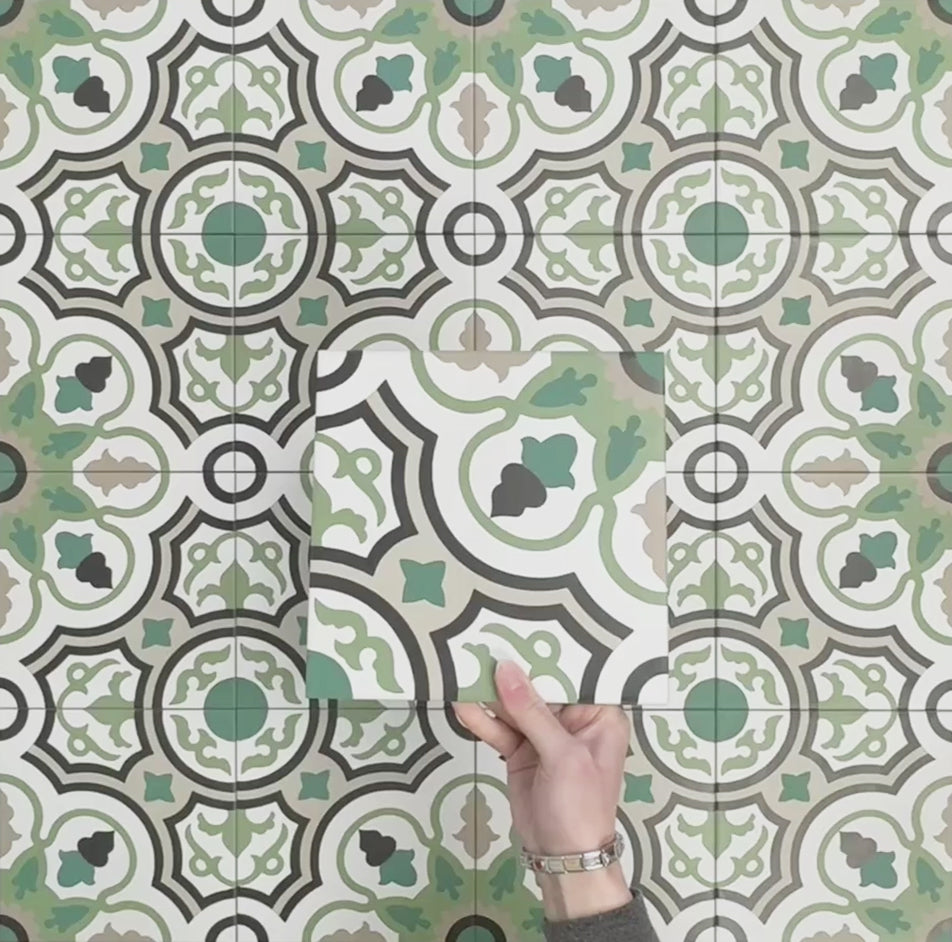 Video showcasing Europa Budapest 20x20cm Victorian Moroccan style tiles arranged together to showcase the repeating geometric pattern in green, cream, black and taupe tones, displayed against a textured green background.