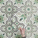 Video showcasing Europa Budapest 20x20cm Victorian Moroccan style tiles arranged together to showcase the repeating geometric pattern in green, cream, black and taupe tones, displayed against a textured green background.