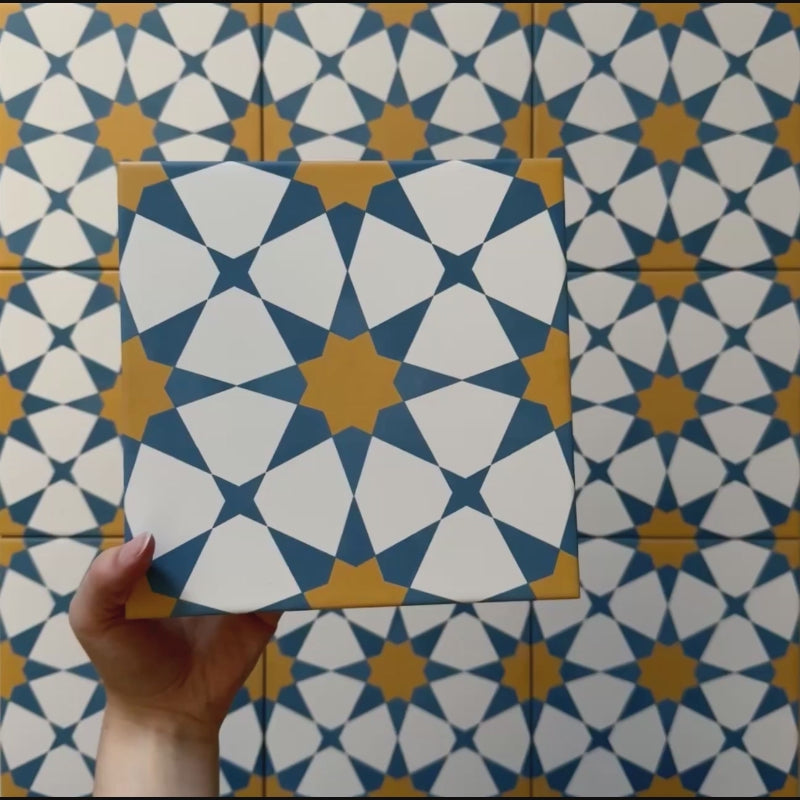 Video showcasing Agraba Sunshine 20x20cm Moroccan-style ceramic tiles, highlighting their geometric star pattern in blue, mustard yellow, and white with a smooth matt finish under natural light.