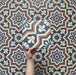 Video showcasing Brompton Grand 20x20cm Victorian-Moroccan-style ceramic tiles with intricate star and floral patterns in navy blue, terracotta, cream, and white tones, highlighting the detailed design and matte finish in a close-up view.