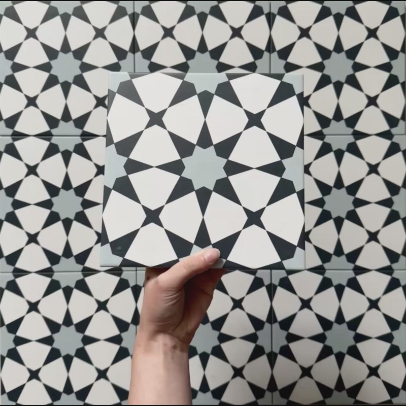 Video showcasing Agraba Azul Blue 20x20cm Moroccan-style ceramic tiles, highlighting their intricate navy, light blue, and white geometric star pattern with a smooth matt finish under natural light.
