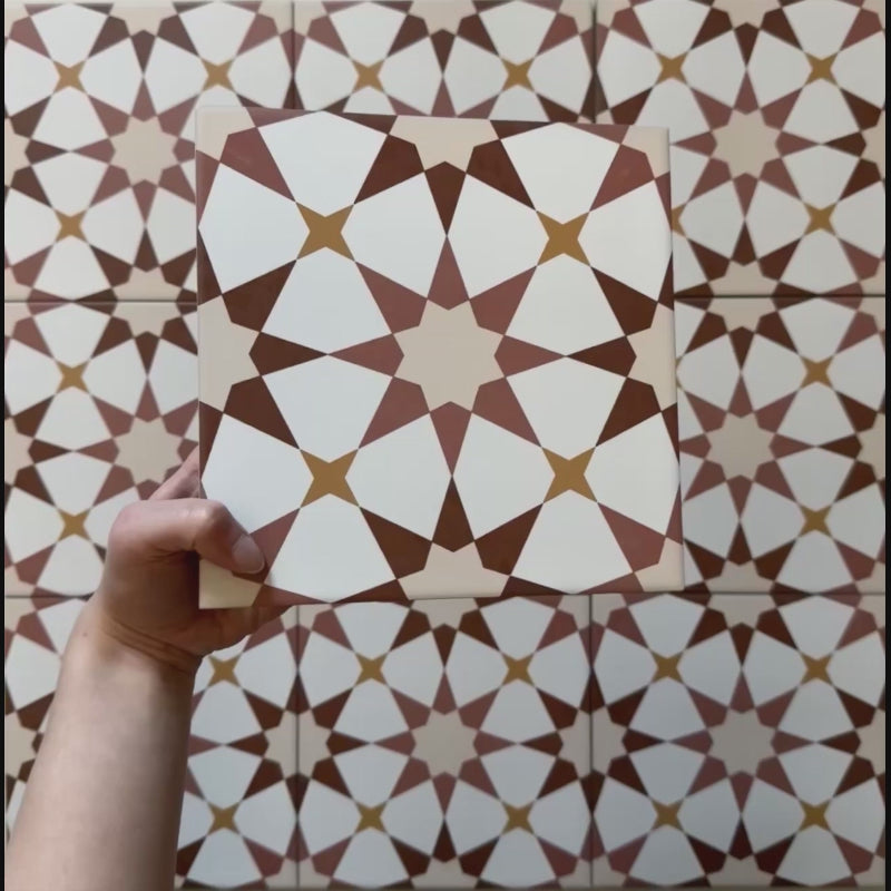 Video showcasing Agraba Cotto 20x20cm Moroccan-style ceramic tiles, featuring a warm terracotta, beige, and white geometric star pattern with a matt finish, shown in close-up under natural light.