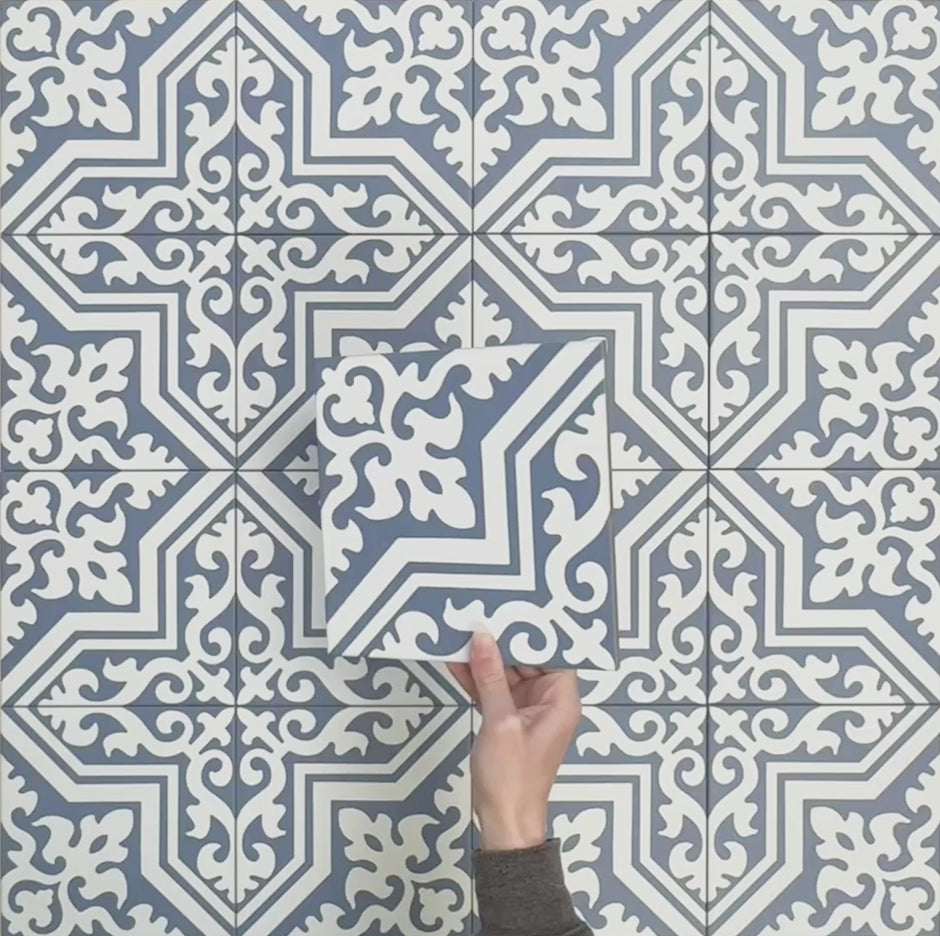 Video showcasing Europa Trondheim Blue 20x20cm Victorian Moroccan style tiles arranged together to showcase the repeating decorative pattern in blue and white tones, displayed against a textured grey background.