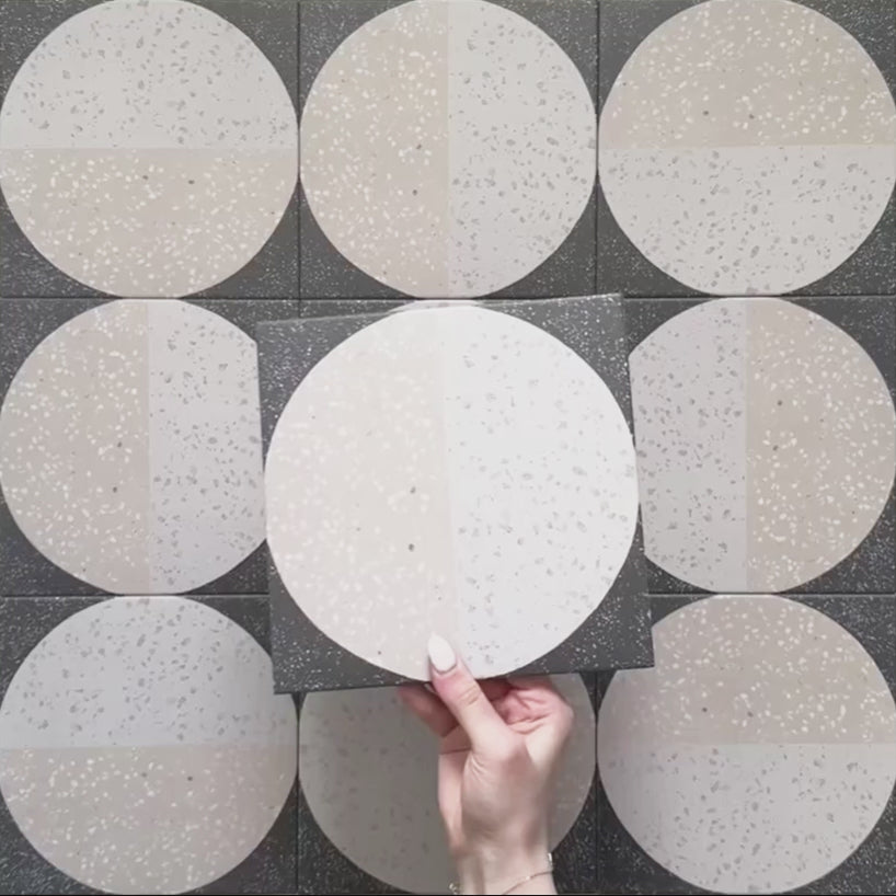 Kasuf Night 20x20cm terrazzo-style decor tiles featuring a bold monochrome circular pattern with speckled terrazzo detailing, ideal for creating statement floors and contemporary geometric interiors.