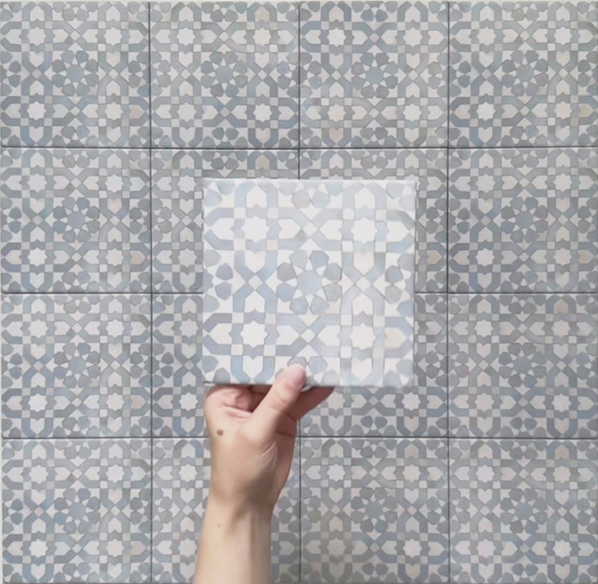 Video showcasing the Bedouin Tetuan Blue Moroccan-style 15x15cm ceramic tiles, highlighting their intricate star and cross pattern in soft blue, white, and beige tones with a handcrafted finish and subtle surface texture under natural lighting.