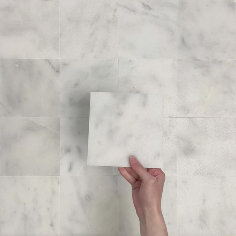 Video showcasing Fitzrovia White 15.2x15.2cm honed natural marble tiles arranged in a square layout, showcasing soft white tones, subtle grey veining, tonal variation, and a smooth, refined finish.