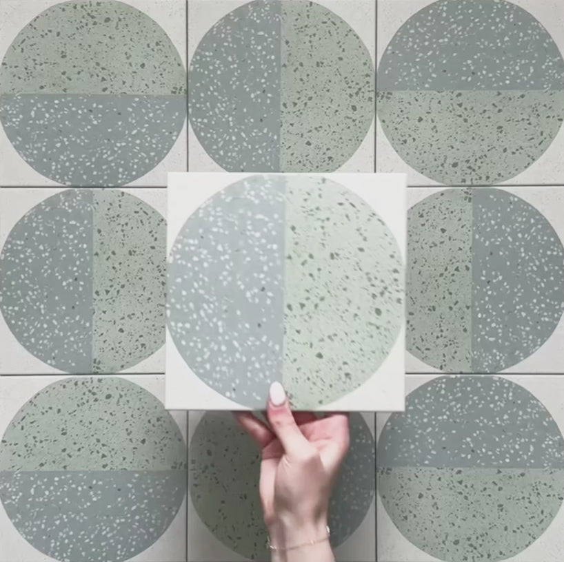 Kasuf Verde 20x20cm terrazzo-style decor tiles featuring a soft sage green and pale blue circular pattern with speckled terrazzo detailing, perfect for creating calming geometric floors and contemporary statement interiors.