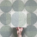 Kasuf Verde 20x20cm terrazzo-style decor tiles featuring a soft sage green and pale blue circular pattern with speckled terrazzo detailing, perfect for creating calming geometric floors and contemporary statement interiors.