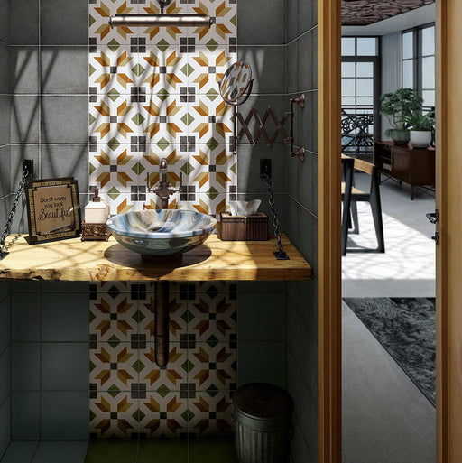 Bathroom sink area featuring Carnaby High Street Victorian-style 20x20cm porcelain wall and floor tiles, showcasing a bold geometric pattern in mustard, green, white, and charcoal tones, styled with a rustic wooden countertop, vessel basin, and dark green surrounding tiles.